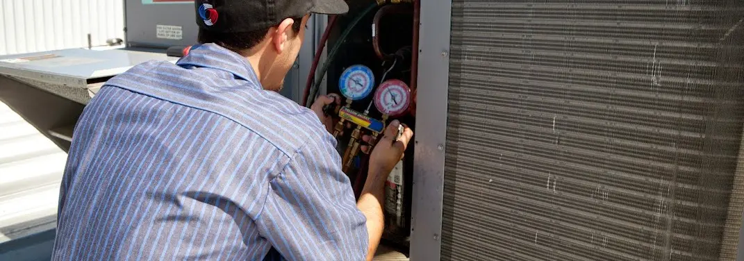 HVAC technician servicing a condenser unit in East Hanover